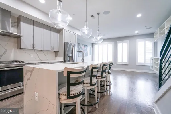 a kitchen with stainless steel appliances granite countertop a refrigerator a sink and a stove