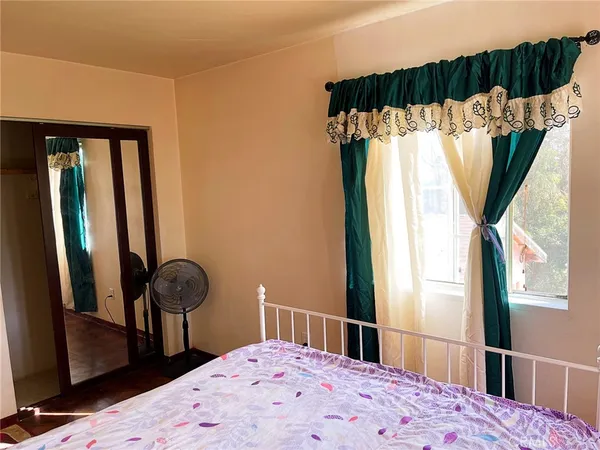 a bedroom with a bed and a large mirror