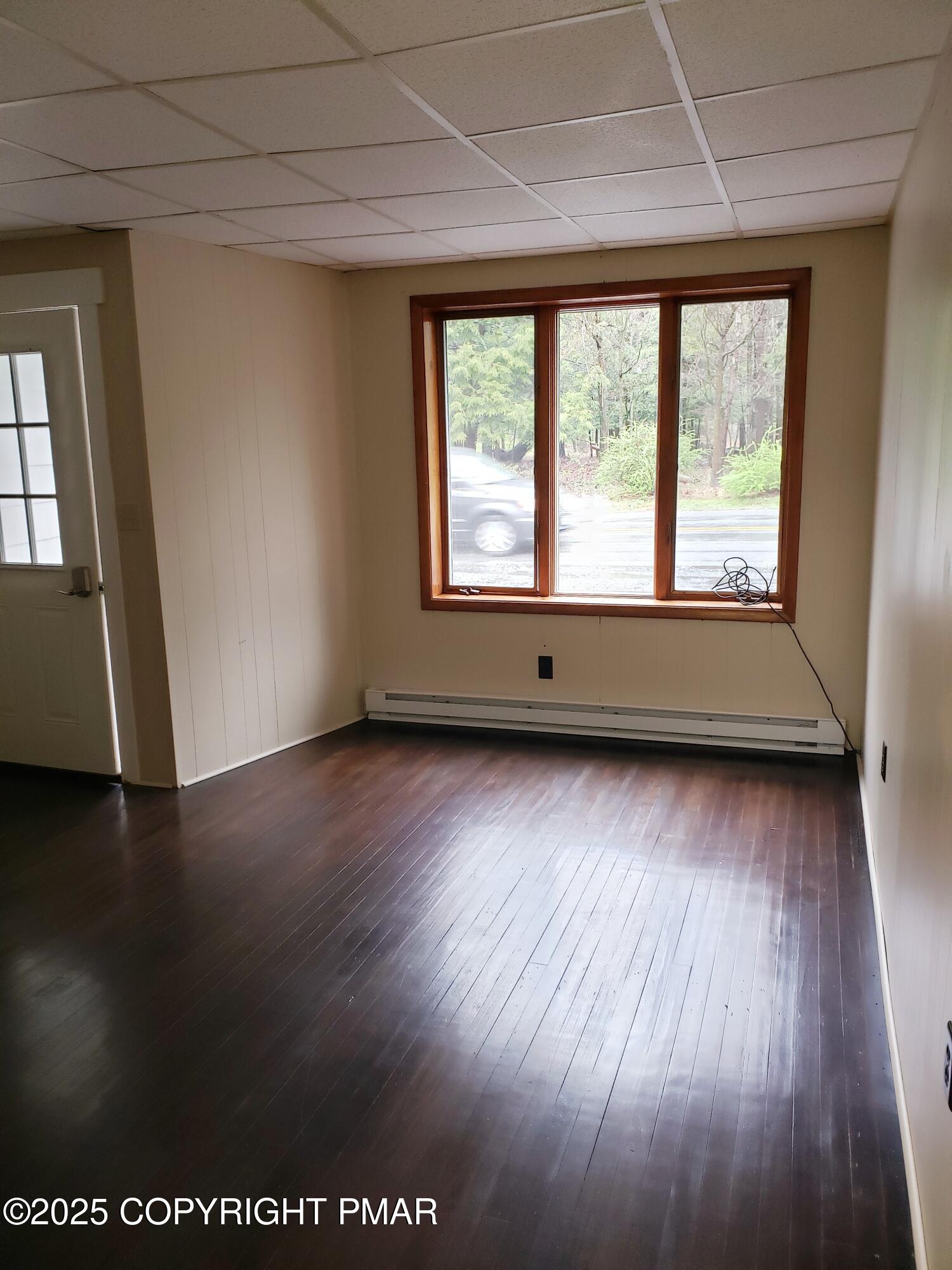 1200 Cherry Lane Road, Unit 102 East Stroudsburg, PA 18301 - Photo 2 of 10 an empty room with wooden floor and windows