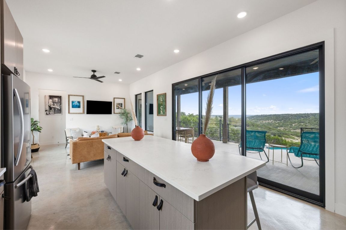 11 Sacramento Boerne, TX 78006 - Photo 16 of 40 Kitchen with concrete floors, freestanding refrigerator, a breakfast bar, a center island, and ceiling fan
