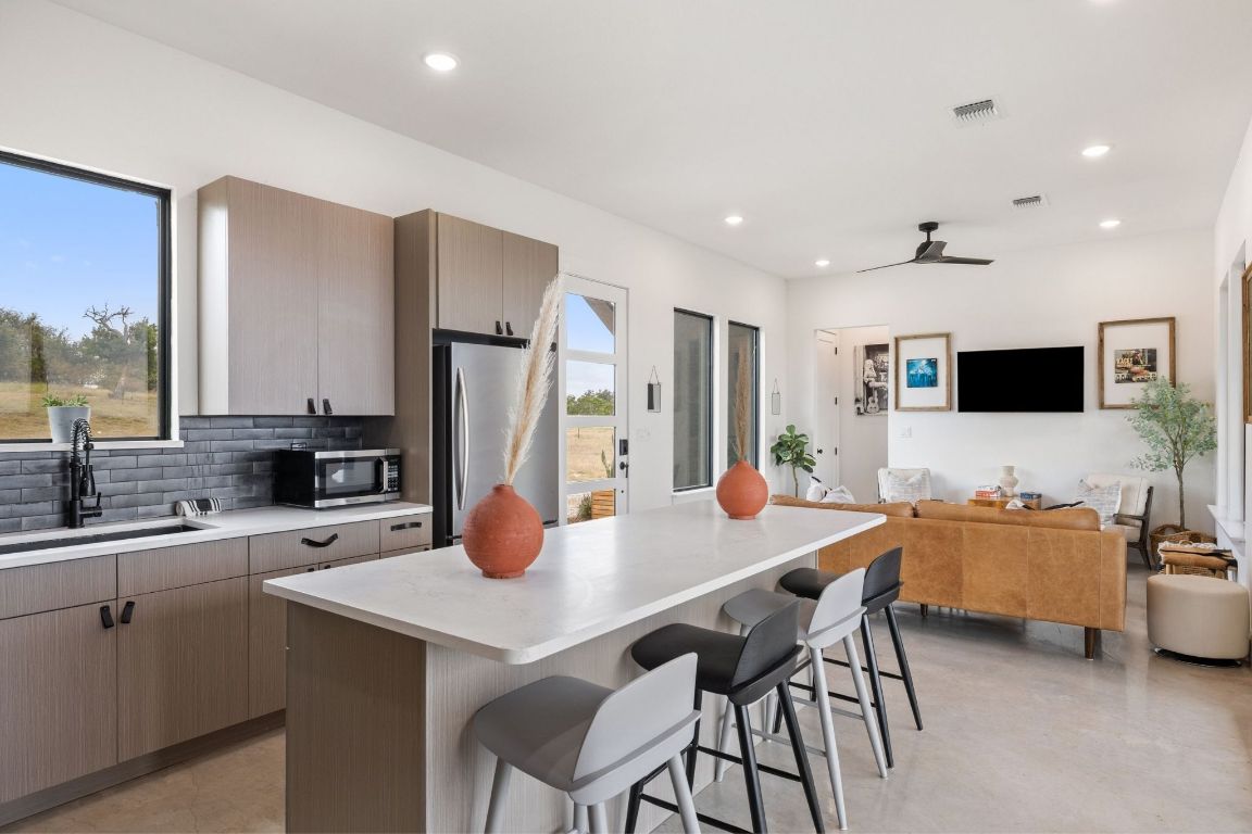 11 Sacramento Boerne, TX 78006 - Photo 40 of 40 Kitchen featuring backsplash, a breakfast bar, open floor plan, appliances with stainless steel finishes, and a kitchen island