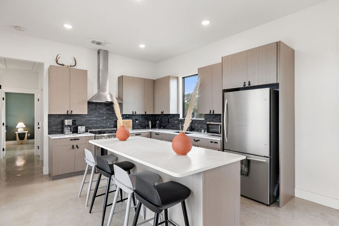 11 Sacramento Boerne, TX 78006 - Photo 17 of 40 Kitchen featuring a breakfast bar area, appliances with stainless steel finishes, backsplash, a center island, and recessed lighting