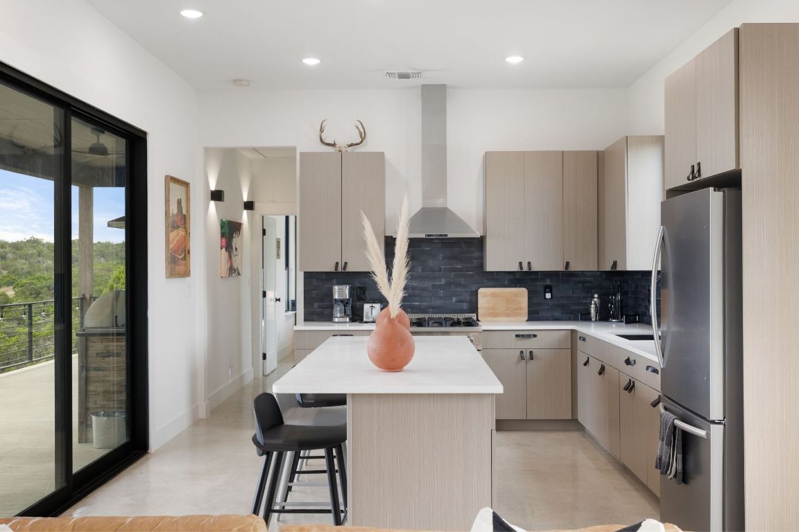 11 Sacramento Boerne, TX 78006 - Photo 18 of 40 Kitchen with light brown cabinets, freestanding refrigerator, tasteful backsplash, a center island, and recessed lighting