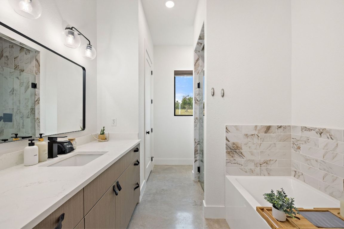 11 Sacramento Boerne, TX 78006 - Photo 25 of 40 Bathroom with finished concrete flooring, vanity, a bath, a marble finish shower, and recessed lighting