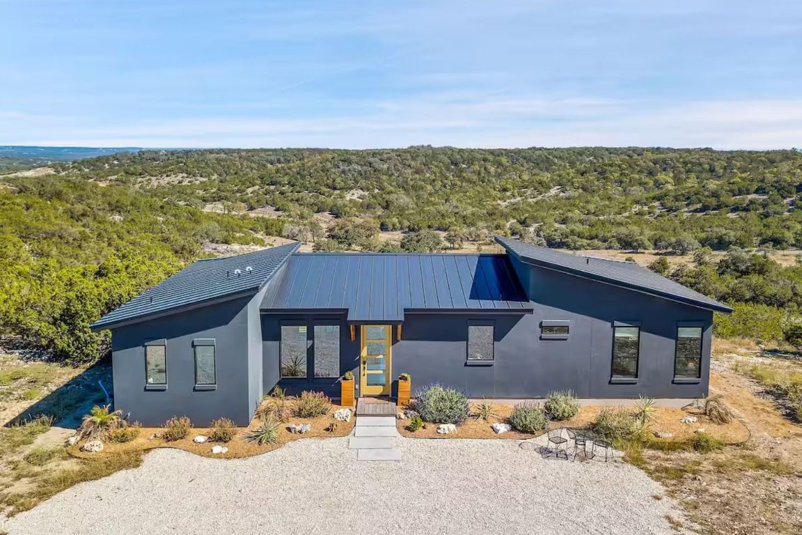 11 Sacramento Boerne, TX 78006 - Photo 4 of 40 View of front of home featuring a forest view, a metal roof, and stucco siding