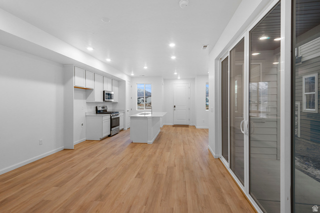 1302 East 1670th North, Unit 908 Payson, UT 84651 - Photo 6 of 21 Kitchen featuring white cabinets, a center island, stainless steel appliances, recessed lighting, and light wood-type flooring