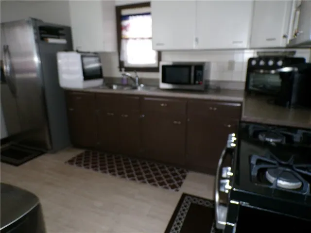 a kitchen with a sink a stove and cabinets