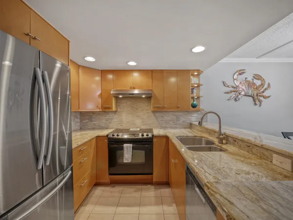 a kitchen with stainless steel appliances granite countertop a sink stove and refrigerator