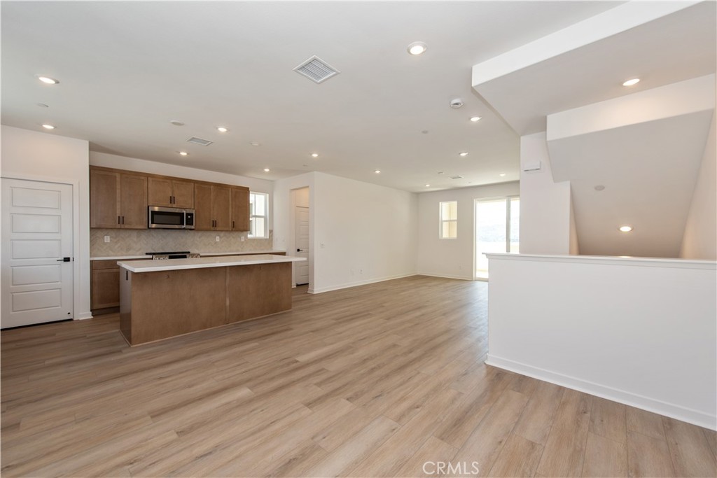 211 Ruby Road Rancho Mission Viejo, CA 92694 - Photo 15 of 41 a large kitchen with stainless steel appliances granite countertop a large counter top a stove and a wooden floors