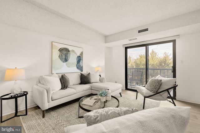 a living room with furniture and a large window with balcony view