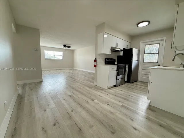 a view of a kitchen with furniture and wooden floor