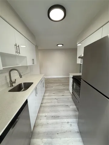 a kitchen with sink cabinets and stainless steel appliances