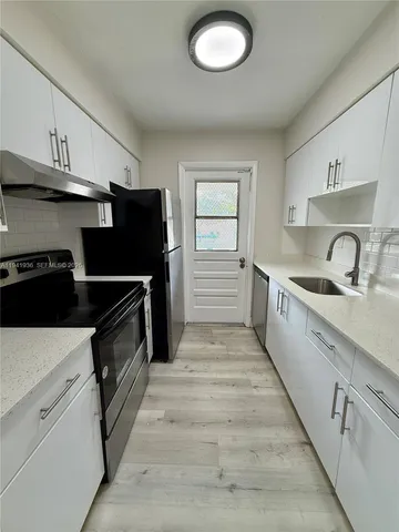 a kitchen with a refrigerator stove and cabinets