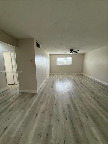 a view of empty room with wooden floor