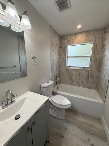 a bathroom with a double vanity sink a toilet and a bathtub