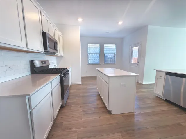 a kitchen with granite countertop a sink and a stove top oven