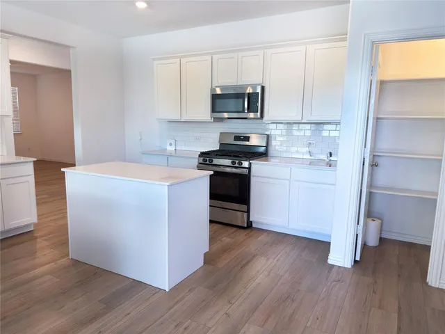 a kitchen with a sink cabinets and wooden floor