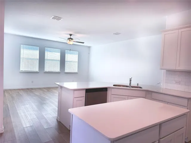 a view of kitchen with cabinets appliances and wooden floor