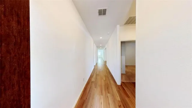 a view of a kitchen with wooden floor and a ceiling fan