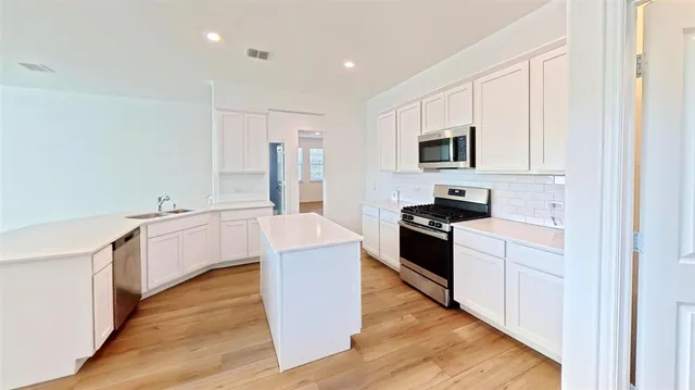 a view of a kitchen with a sink and wooden floor