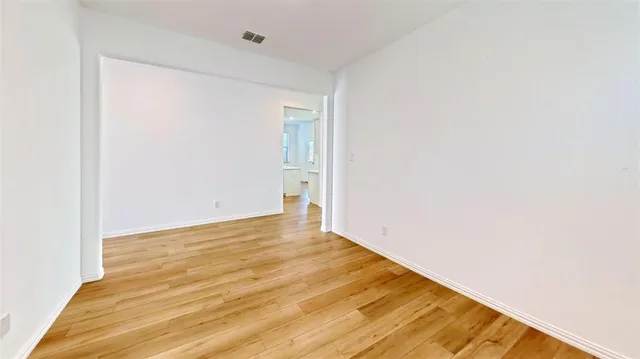 a large white kitchen with stainless steel appliances granite countertop a stove and a sink