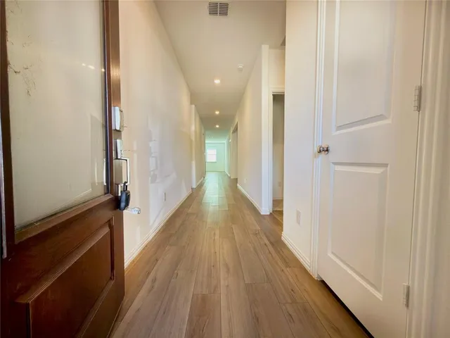 a view of a hallway with wooden floor