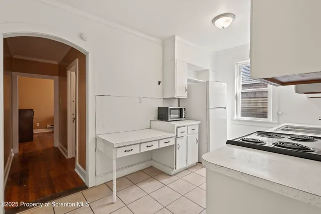 a kitchen with stainless steel appliances a stove a sink and white cabinets