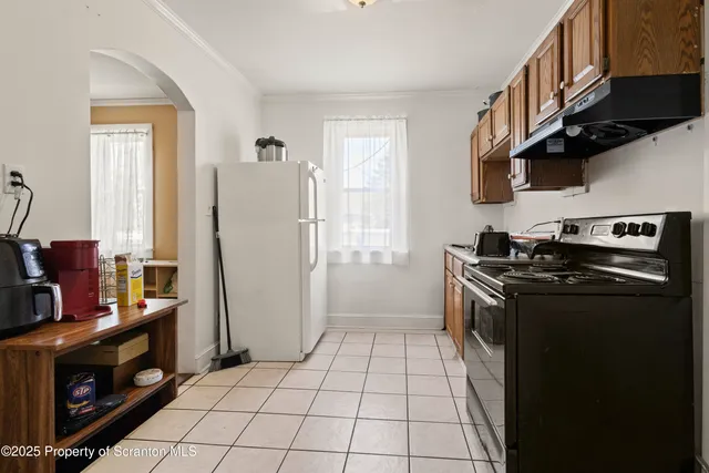 a kitchen with stainless steel appliances granite countertop a refrigerator a stove and a sink