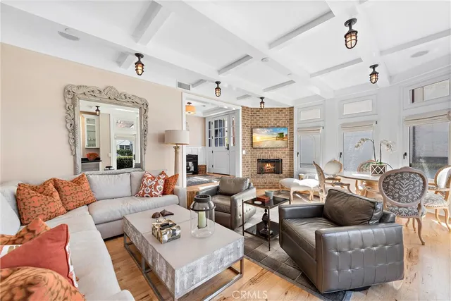 a living room with furniture couches and a dining table with wooden floor