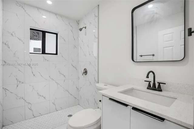 a bathroom with a toilet sink and mirror
