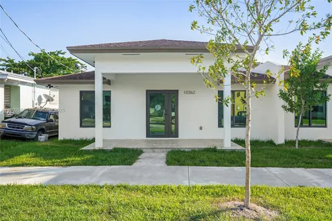 a front view of a house with a garden and plants