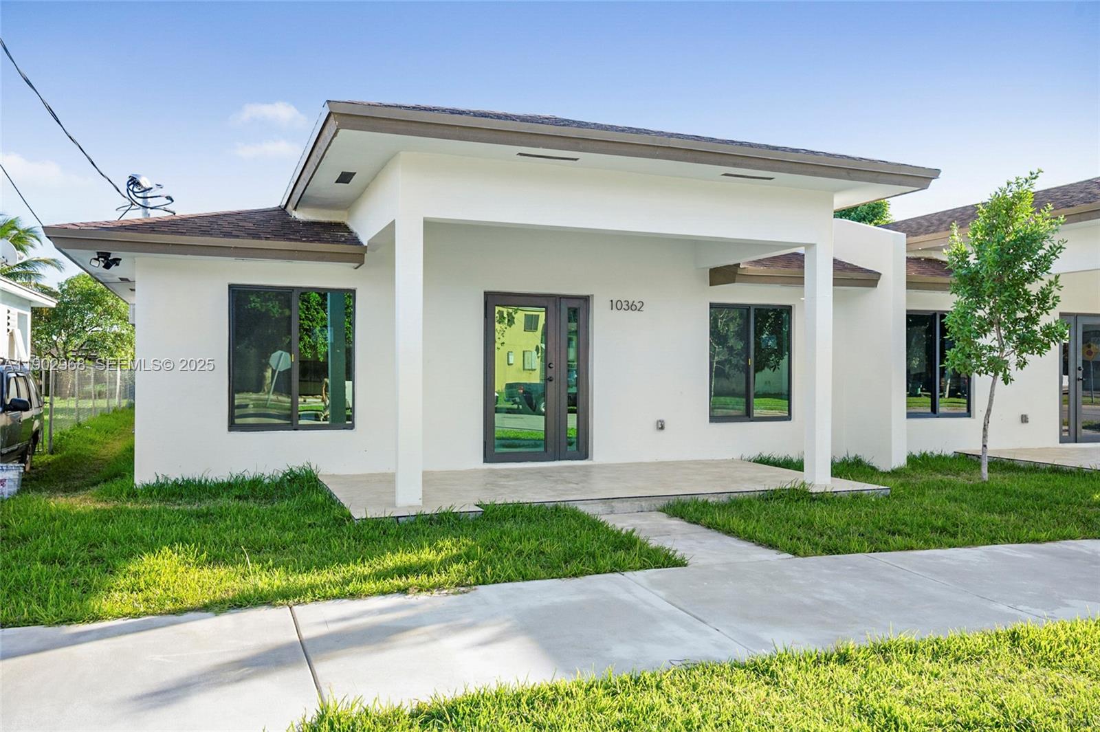 10362 Southwest 180th Street Miami, FL 33157 - Photo 3 of 18 a front view of a house with a yard and potted plants