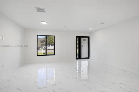 an empty room with windows and cabinet