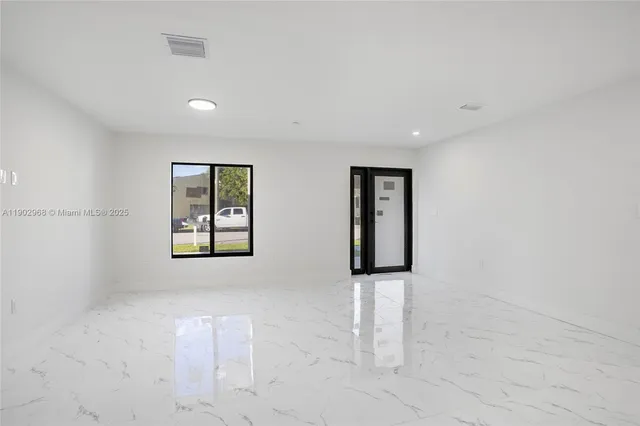 an empty room with windows and cabinet