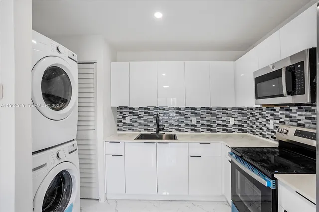 a kitchen with granite countertop white cabinets and black appliances