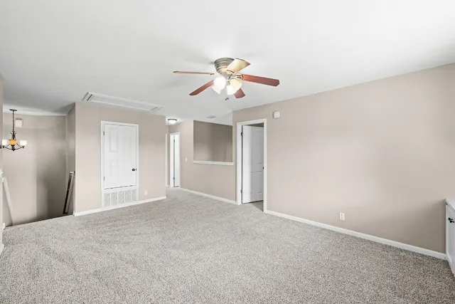 a view of a room with a ceiling fan and a window