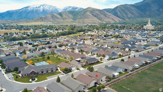 1204 South 1150th Street West Payson, UT 84651 - Photo 16 of 26 Spacious residential community featuring a variety of home styles, a central recreation building with tennis courts, and a backdrop of snow-capped mountains