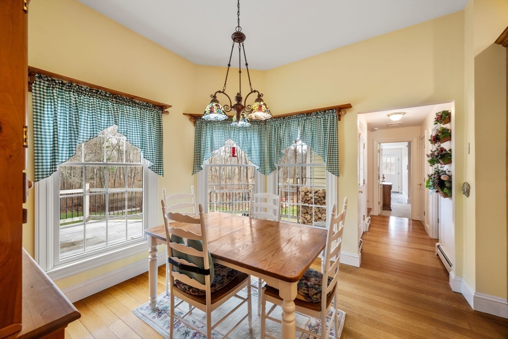 332 Division Road Dartmouth, MA 02748 - Photo 11 of 42 a dining room with wooden floor a chandelier a glass table and chairs