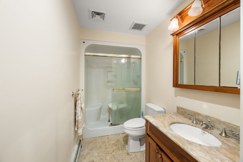 332 Division Road Dartmouth, MA 02748 - Photo 22 of 42 a bathroom with a granite countertop sink toilet a mirror and shower