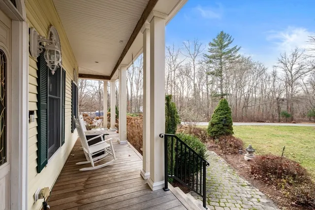 a balcony with chairs and wooden floor