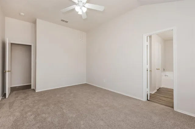 an empty room with a chandelier fan