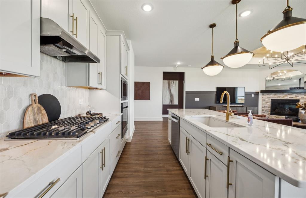 1609 Tyler Drive Anna, TX 75409 - Photo 4 of 16 a large kitchen with stainless steel appliances kitchen island a large stove a sink dishwasher and a microwave with wooden floor