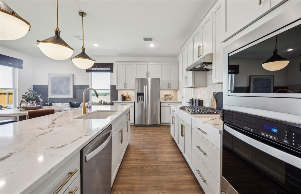 1609 Tyler Drive Anna, TX 75409 - Photo 5 of 16 a large kitchen with stainless steel appliances granite countertop a stove and a sink