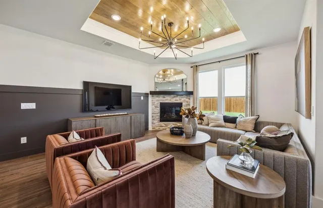 a living room with furniture a flat screen tv and a large window