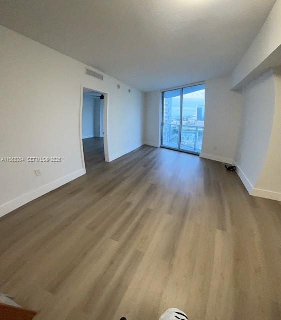 185 Southwest 7th Street, Unit 1605 Miami, FL 33130 - Photo 12 of 22 an empty room with wooden floor and windows