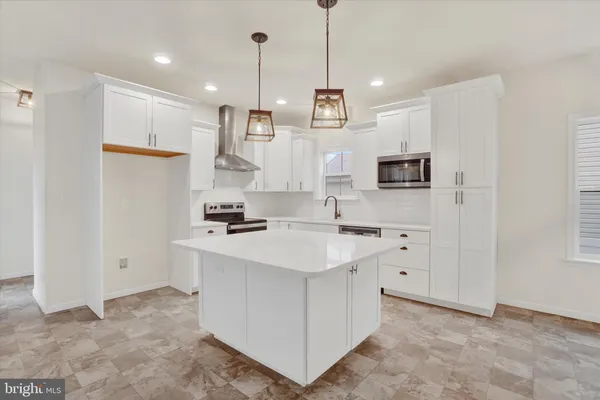 a kitchen with kitchen island white cabinets and refrigerator