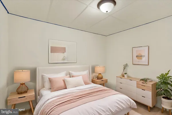 a bedroom with a bed and a lamp on the dresser