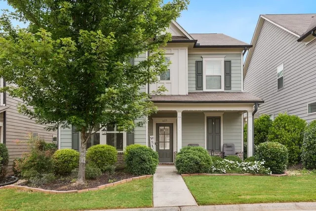 a front view of a house with a yard and trees