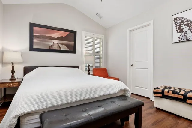 a bedroom with a bed and a lamp on table