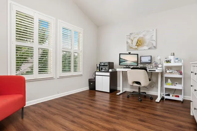a view of a workspace with furniture and a window